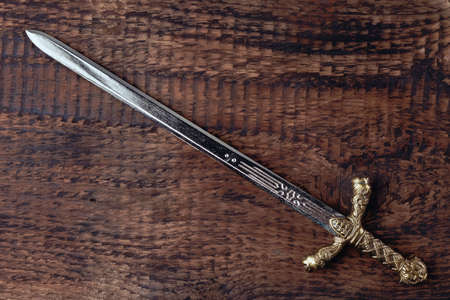 Antique knights sword on the background of gray wood texture.の写真素材