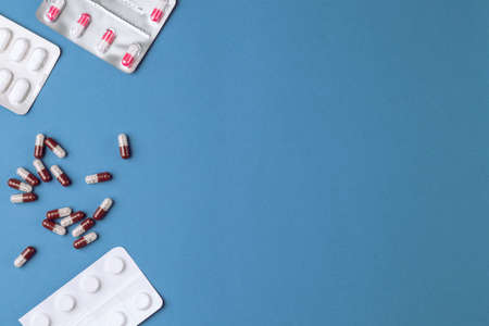 Medical drugs in packaging and in bulk on a blue background.の写真素材