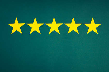 Rating in the form of yellow stars on a green background. The concept of service quality assessment.の写真素材