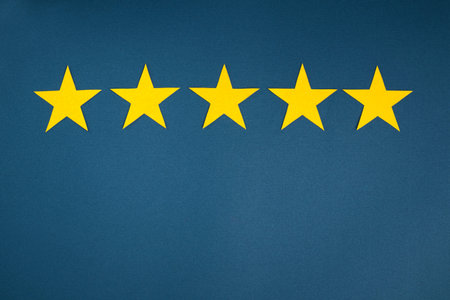 Rating in the form of yellow stars on a blue background. The concept of service quality assessment.の写真素材