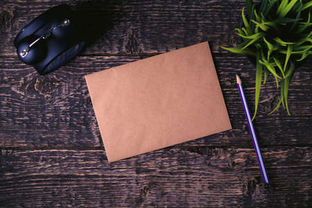 Blank sheet of old paper, alarm clock, pencil and houseplant on wooden table texture. Flat lay, copy spaceの写真素材