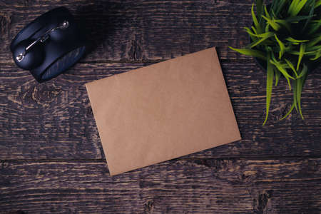 Blank sheet of old paper, alarm clock and houseplant on wooden table texture. Flat lay, copy spaceの写真素材