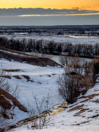 Evening view of the ravine with a stream from melted snow at sunset. The coming of springの写真素材