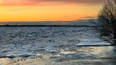 Spring ice drift on the river at sunset.の写真素材