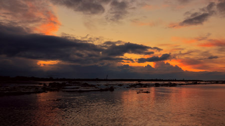 Dramatic sunset over the river surface with floating ice floes.の写真素材