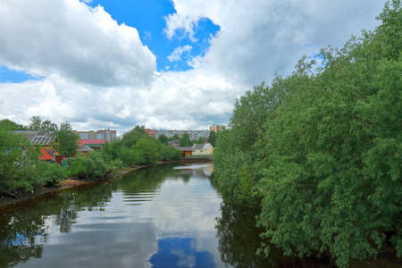 Beautiful summer view of the river in the city with overgrown banks. Russia, Arkhangelskの写真素材