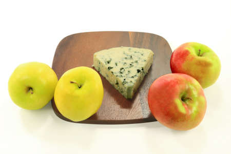 Stock Photo of wedge Blue Cheese over wooden platter served with two types Tart Apples over white background   の写真素材
