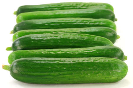 Stock Photo of group of Baby Cucumbers ordered in line over white background  の写真素材
