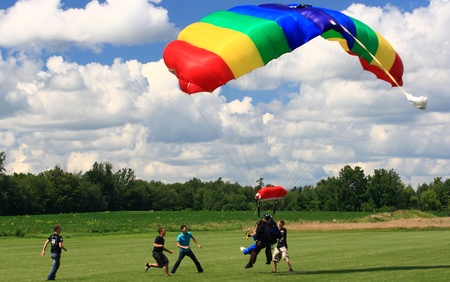 WATERDOWN, ONTARIO CANADA - AUGUST 2013  Skydivers in tandem jump just before land with security...
