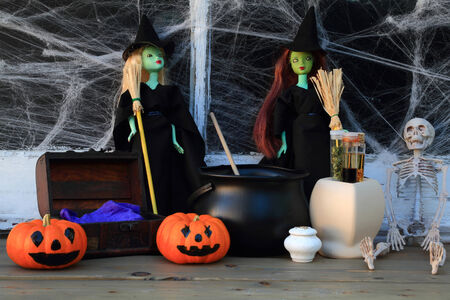 Halloween Witches in location with spider web cover window and decorated with skeleton, scary pumpkins, secret ingredients, treasure chest cooking their magical liquid for the Night of All Hallowのeditorial素材