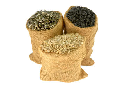 Different kind (sorts) (Black Oil known as well as bird seeds, Striped and Hulled known as well unshelled) Sunflower seeds in burlap bags (sacks) over white backgroundの写真素材