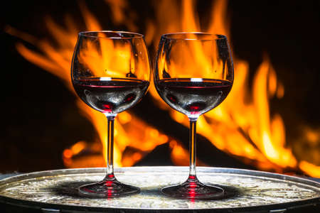 two glasses of wine on the background of fireの写真素材