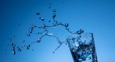 water splashing out of a glassの写真素材