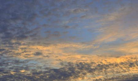 The blue sky at dawn, the sun's rays break through the clouds.