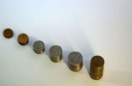 Coins lie in piles. Isolate on white background Close up.の写真素材