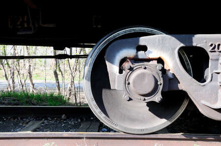 Part of the wheelset and bottom of a freight railway carriage on rails. Close-up.の写真素材