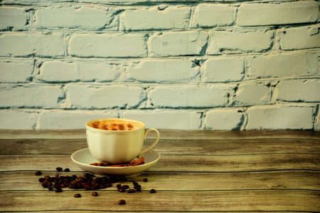 A cup of fresh cappuccino with topping on a saucer decorated with coffee beans and cinnamon. Close-up.の写真素材