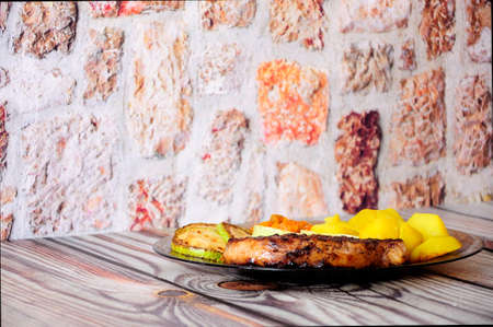 Grilled pork fillet with boiled potatoes and vegetables. Close-up.
