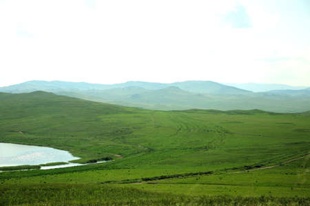 A fragment of a calm lake lying in a picturesque valley filled with sunlight. Lake Matarak, Khakassia, Southern Siberia, Russia.の写真素材