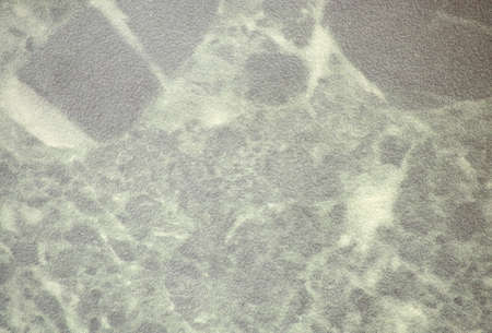 Dark gray marble with a rich layered pattern, close-up of a polished flat surface of natural stone....