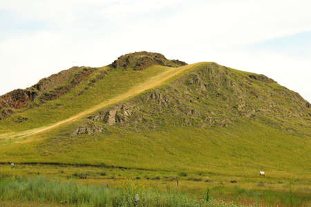 Walking trail to the top of a high hill with natural stone fences along the edges. Khakassia, Siberia, Russia.の写真素材