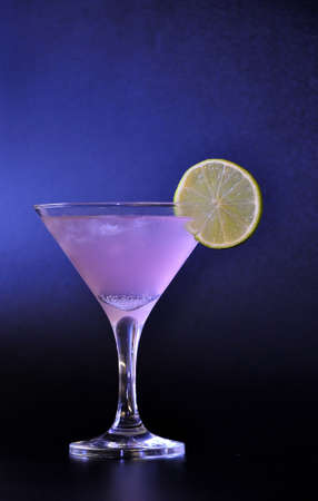 Tall glass of Cosmopolitan cocktail with a slice of ripe lime on a black background. Close-up.の写真素材
