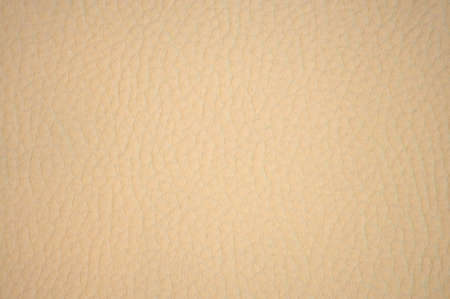 A fragment of pale beige genuine leather with wrinkles and folds, close-up. Background, pattern, texture.の写真素材