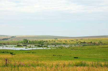 A small picturesque lake near the slope of high hills in the endless steppe. Khakassia, Siberia, Russia.の写真素材