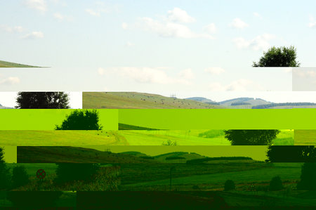 A two-lane asphalt road curves through a picturesque hilly valley on a warm summer day. Khakassia,...