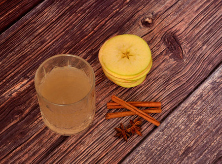 Apple liqueur with cinnamon and anise on a black background, homemade alcohol, spices and ripe fruits. Close-up.の写真素材