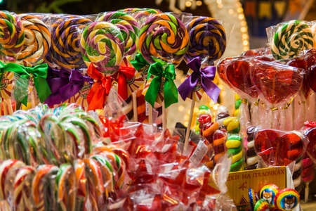 Multicolored beautiful sweet New Year's candy on a stick and cockの写真素材