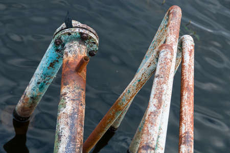 Iron rusty pipes going into the depths of the lakeのeditorial素材