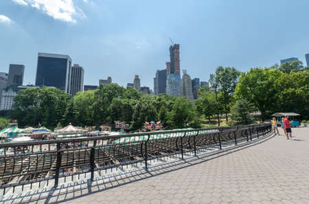 NEW YORK CITY - JULY 12: Victorian Gardens with the skyscrapers of Central Park South on July 12, 2012 in New York. Victorian Gardens is a seasonal traditional-style amusement park, which is located in the Wollman Rink of Central Park in Manhattan.のeditorial素材