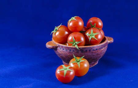 Cherry tomatoes in clay bowlの写真素材