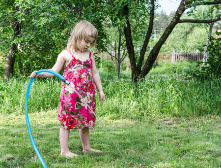 Girl play with water hoseの写真素材