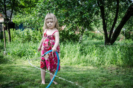 Girl play with water hoseの写真素材