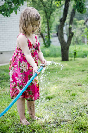 Girl plays with water hoseの写真素材
