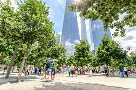 NEW YORK - JULY 17: People walk near Freedom Tower (1 WTC) in Manhattan on July 17, 2014. One World...