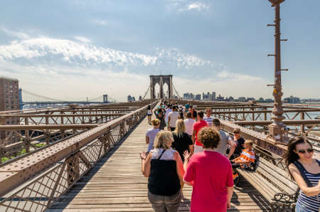 NEW YORK - JULY 17: People walk on Brookly Bridgre in New York City on July 17, 2014. The Brooklyn Bridge is a bridge in New York City and is one of the oldest suspension bridges in the United States.のeditorial素材