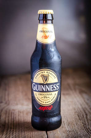SUMY, UKRAINE - OCTOBER 26, 2014: A bottle of Guinness beer on a wooden background. Guinness is one of the most successful beer brands worldwide.のeditorial素材
