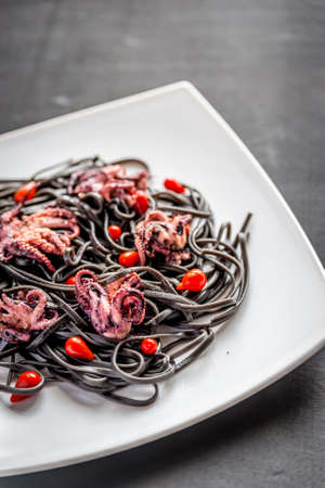 Black pasta with octopus and peppersの写真素材