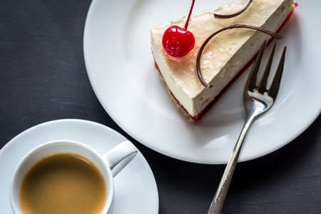 Cherry cheesecake with cup of coffeeの写真素材