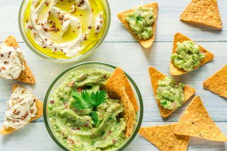 Bowls of hummus and guacamole with tortilla chipsの写真素材