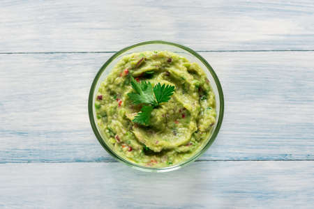 Bowl of guacamole on the wooden tableの写真素材