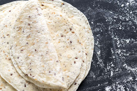 Stack of tortillas on a black surfaceの写真素材