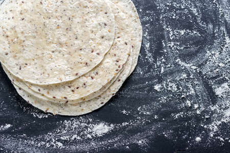 Stack of tortillas on a black surfaceの写真素材