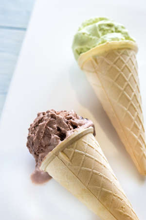 Two cones of nut-flavored ice cream on the white background