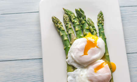 Steamed asparagus with poached eggs on the plateの写真素材