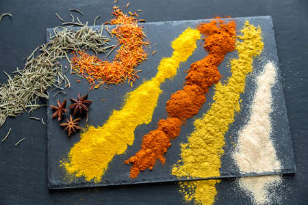 Different kinds of spices and herbs on the black backgroundの写真素材