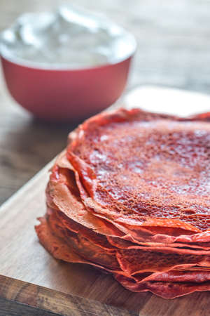 Red velvet crepes with whipped cream on the wooden boardの写真素材